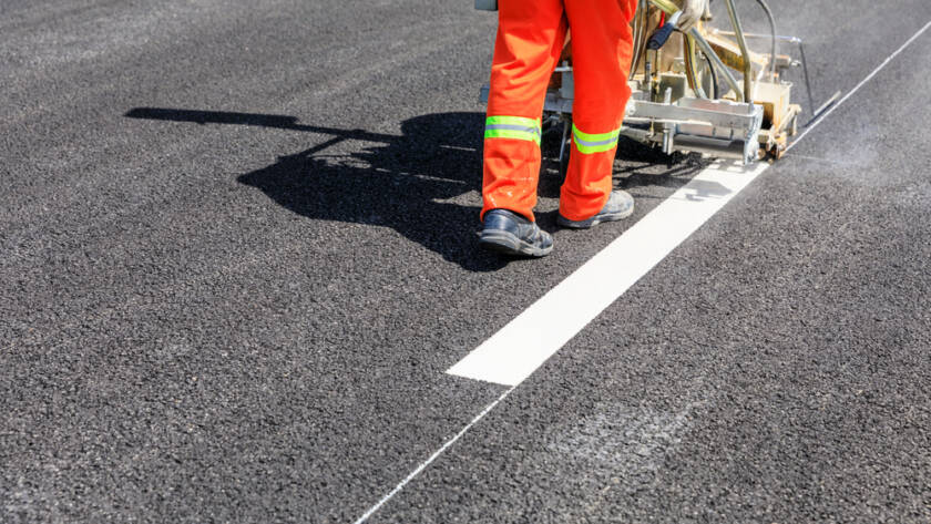 Road workers use hot-melt scribing machines to paint dividing lines